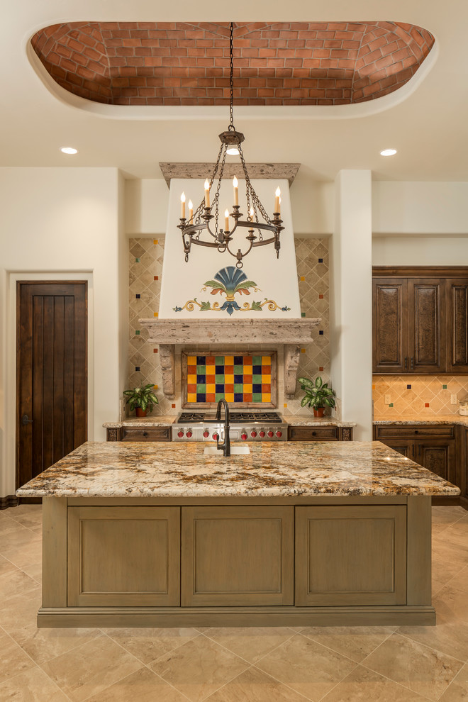 Large tuscan u-shaped travertine floor enclosed kitchen photo in Phoenix with a drop-in sink, raised-panel cabinets, dark wood cabinets, granite countertops, multicolored backsplash, ceramic backsplash, stainless steel appliances and an island