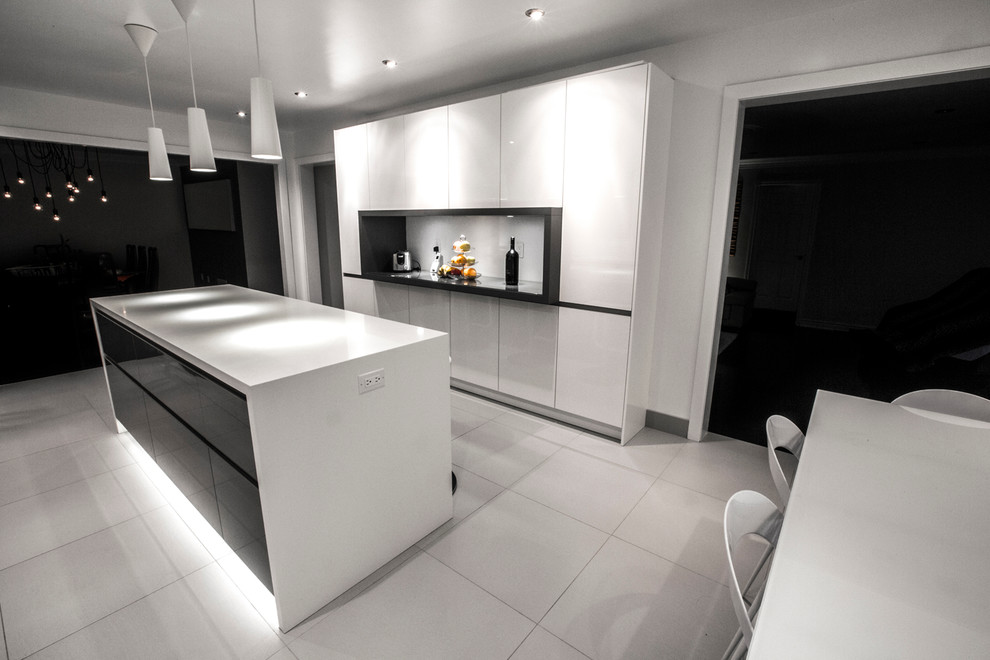 Foto di una cucina moderna con lavello sottopiano, ante lisce, ante bianche, top in quarzite, paraspruzzi bianco e elettrodomestici in acciaio inossidabile