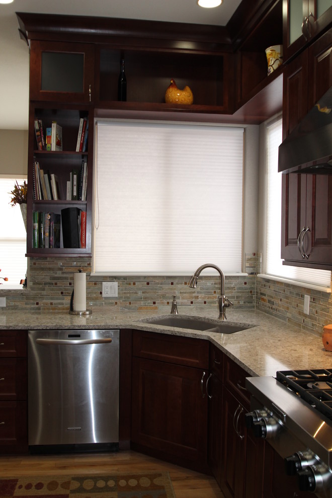 Photo of a medium sized traditional u-shaped enclosed kitchen in Denver with a submerged sink, raised-panel cabinets, red cabinets, engineered stone countertops, multi-coloured splashback, mosaic tiled splashback, stainless steel appliances, light hardwood flooring and a breakfast bar.