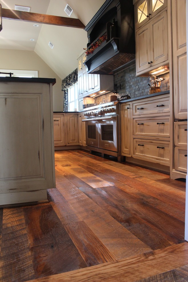 Medium sized rustic u-shaped kitchen in DC Metro with dark hardwood flooring, recessed-panel cabinets, white cabinets, composite countertops, grey splashback, stone tiled splashback, stainless steel appliances and an island.