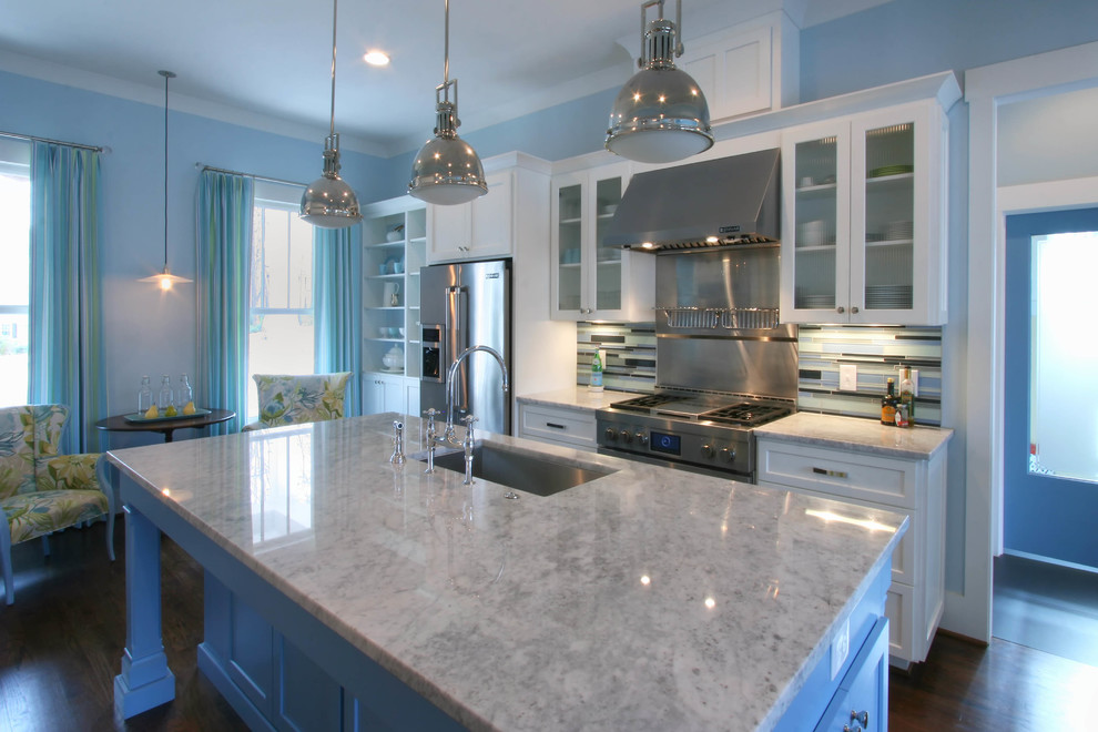 Immagine di una cucina tradizionale con lavello sottopiano, ante lisce, ante bianche, top in marmo, paraspruzzi blu, paraspruzzi con piastrelle di vetro, elettrodomestici in acciaio inossidabile e parquet scuro
