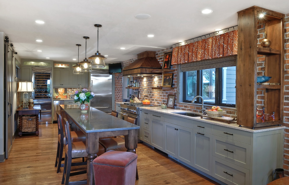 Inspiration for a medium sized classic l-shaped kitchen/diner in Charleston with a submerged sink, stainless steel appliances, recessed-panel cabinets, grey cabinets, engineered stone countertops, an island, red splashback and medium hardwood flooring.