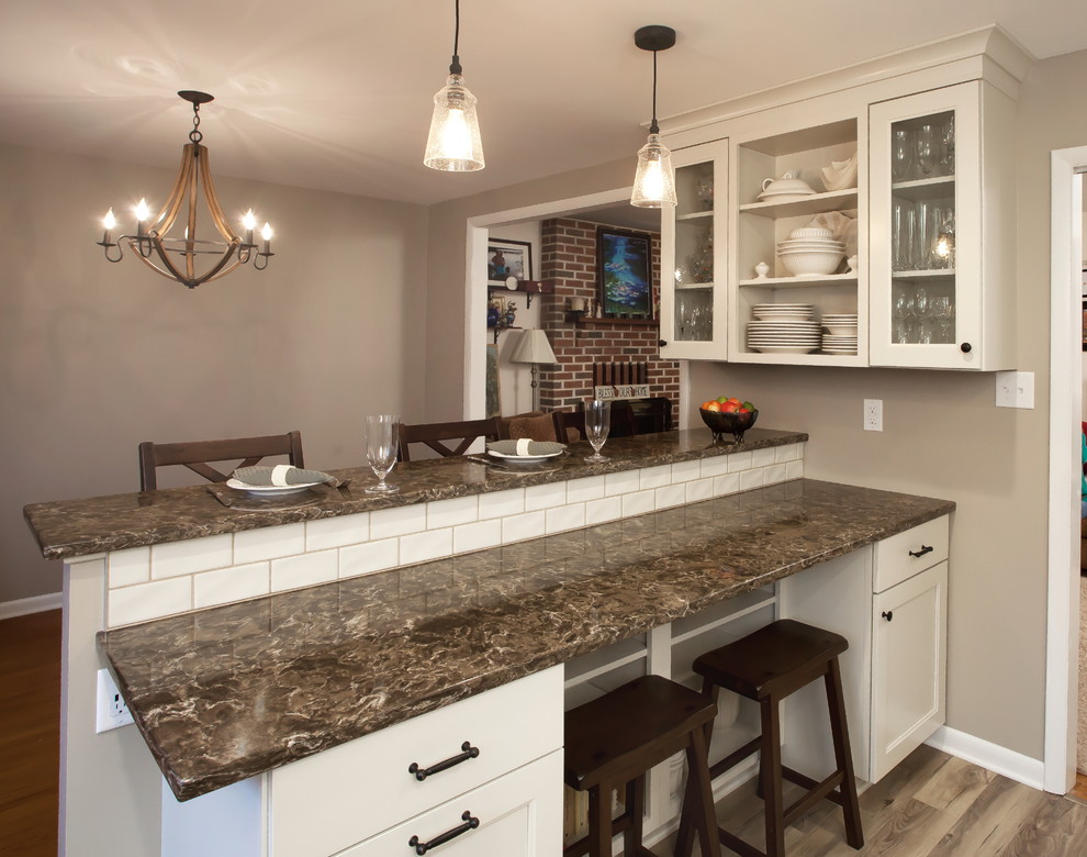 Inspiration for a medium sized classic kitchen/diner in Philadelphia with a submerged sink, shaker cabinets, white cabinets, engineered stone countertops, white splashback, ceramic splashback, stainless steel appliances and a breakfast bar.