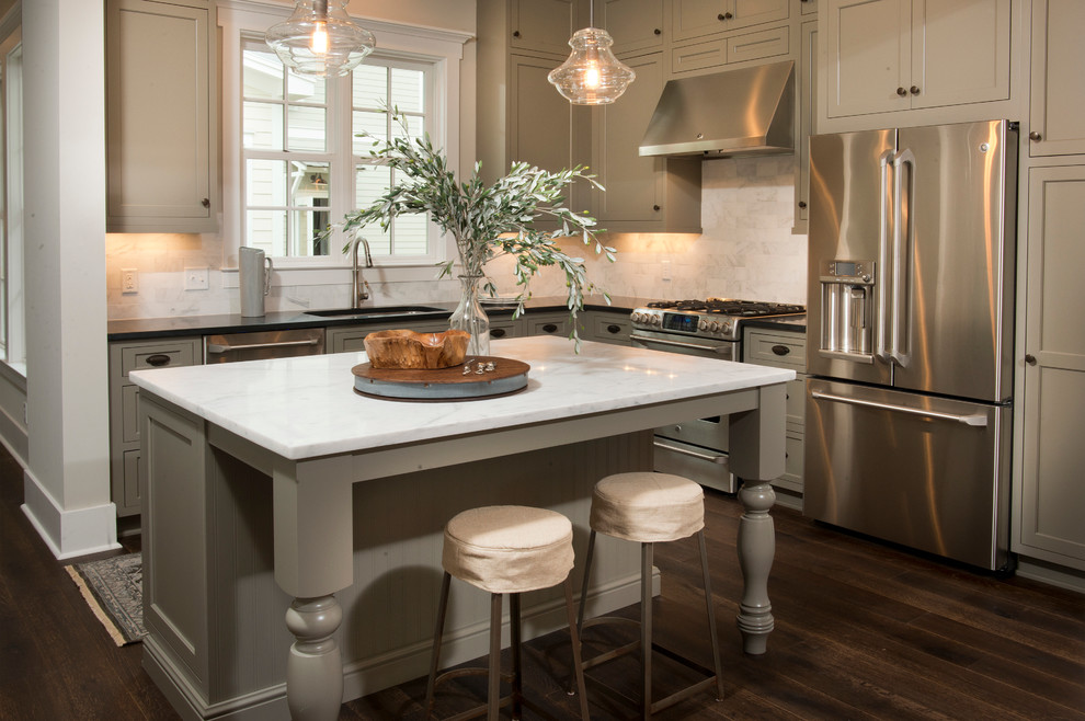 Klassische Küche in L-Form mit Küchenrückwand in Weiß, Küchengeräten aus Edelstahl, dunklem Holzboden, Unterbauwaschbecken, Schrankfronten im Shaker-Stil, grauen Schränken und Kücheninsel in Atlanta