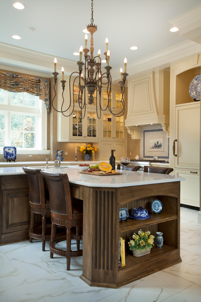Bild på ett stort kök och matrum, med en undermonterad diskho, luckor med profilerade fronter, skåp i slitet trä, bänkskiva i kvarts, integrerade vitvaror, marmorgolv och en köksö