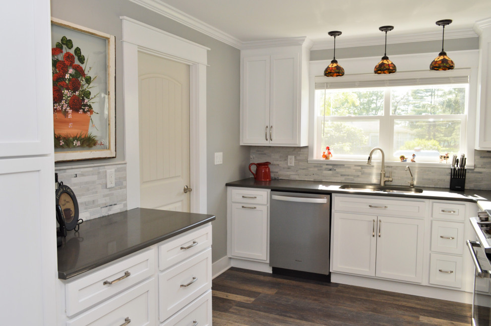 Medium sized classic l-shaped kitchen/diner in Chicago with a submerged sink, shaker cabinets, white cabinets, quartz worktops, grey splashback, stone tiled splashback, stainless steel appliances, laminate floors, no island, brown floors and grey worktops.