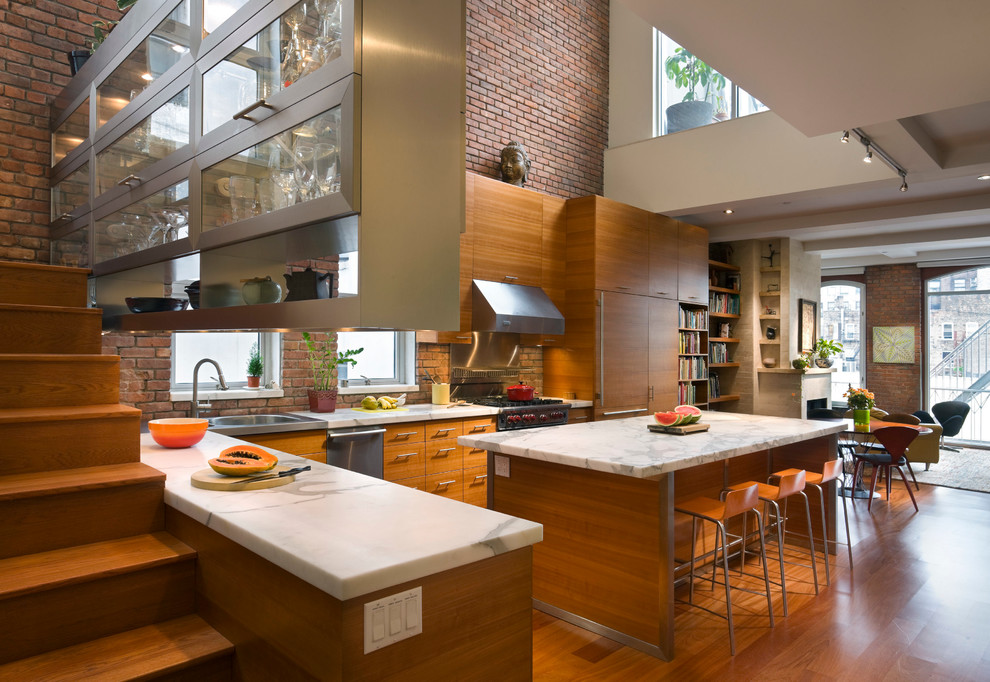 Offene Moderne Küche in L-Form mit flächenbündigen Schrankfronten, hellbraunen Holzschränken, Marmor-Arbeitsplatte und braunem Holzboden in New York