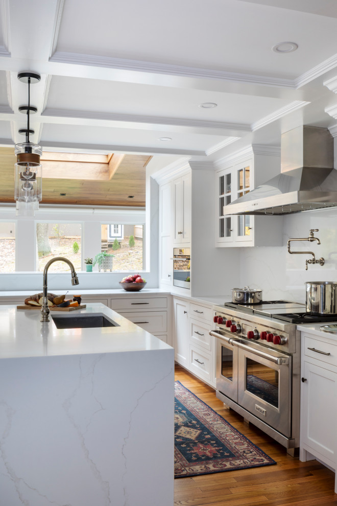 This is an example of a large classic l-shaped kitchen in Boston with a single-bowl sink, recessed-panel cabinets, white cabinets, marble worktops, white splashback, marble splashback, stainless steel appliances, medium hardwood flooring, an island and yellow worktops.