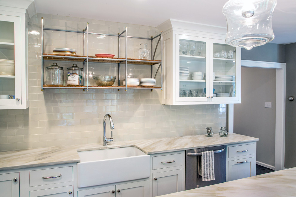 Example of a transitional l-shaped dark wood floor eat-in kitchen design in Philadelphia with a farmhouse sink, white cabinets, white backsplash, stainless steel appliances, an island, shaker cabinets and subway tile backsplash
