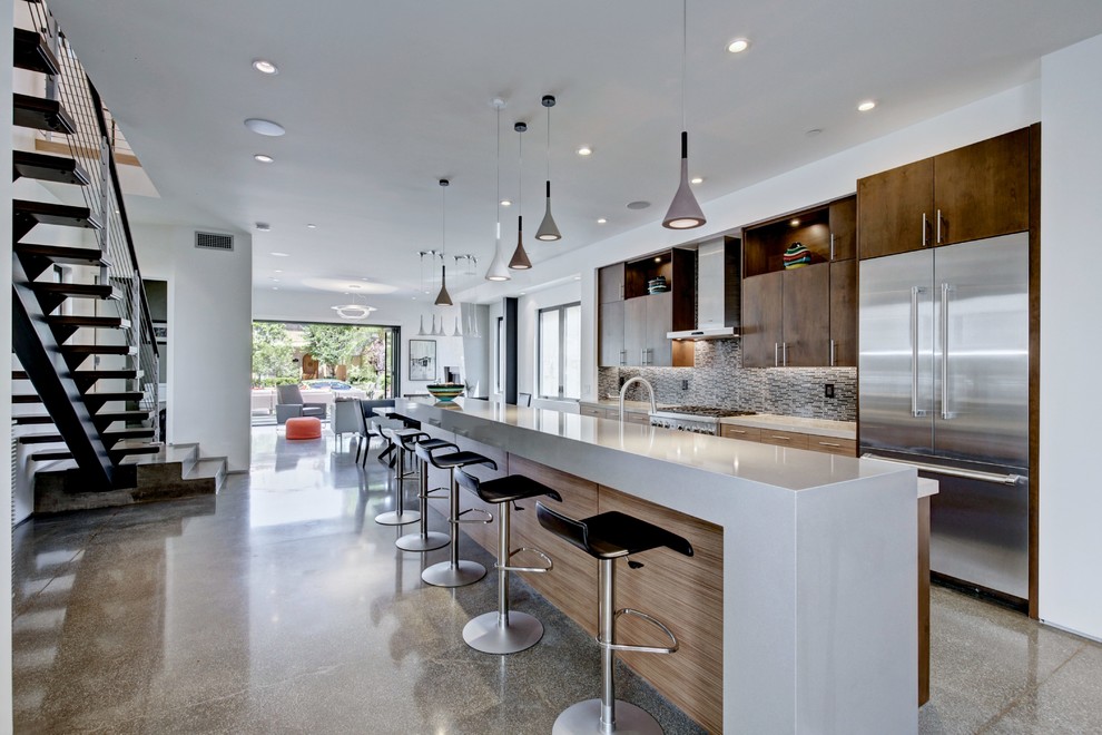 Design ideas for a contemporary galley open plan kitchen in Orange County with dark wood cabinets, grey splashback, stainless steel appliances, an island, flat-panel cabinets and mosaic tiled splashback.