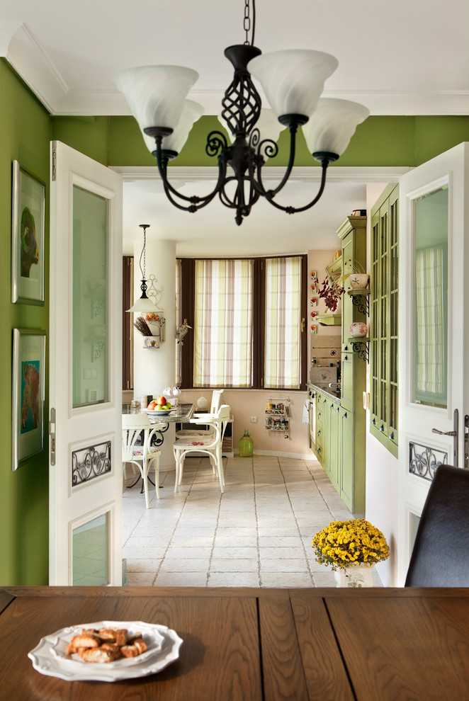 Inspiration för mellanstora lantliga kök, med en integrerad diskho, luckor med upphöjd panel, gröna skåp, granitbänkskiva, beige stänkskydd, stänkskydd i sten, färgglada vitvaror, klinkergolv i terrakotta och en halv köksö
