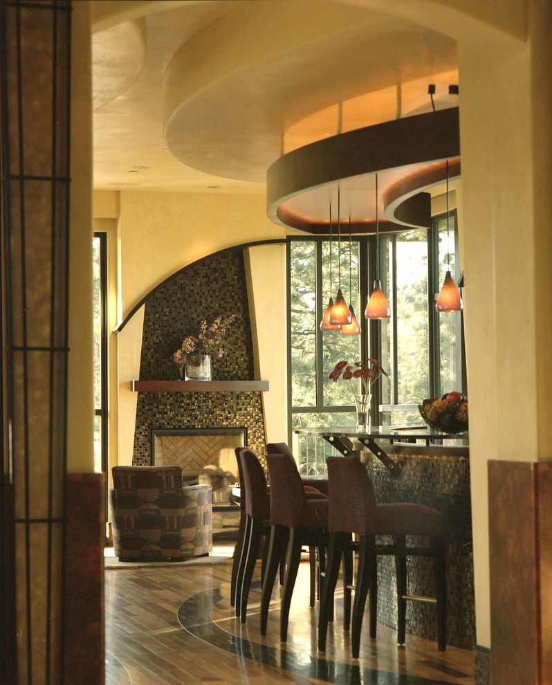 Imagen de cocina lineal actual grande abierta con salpicadero marrón, salpicadero de azulejos de vidrio, suelo de madera en tonos medios y una isla