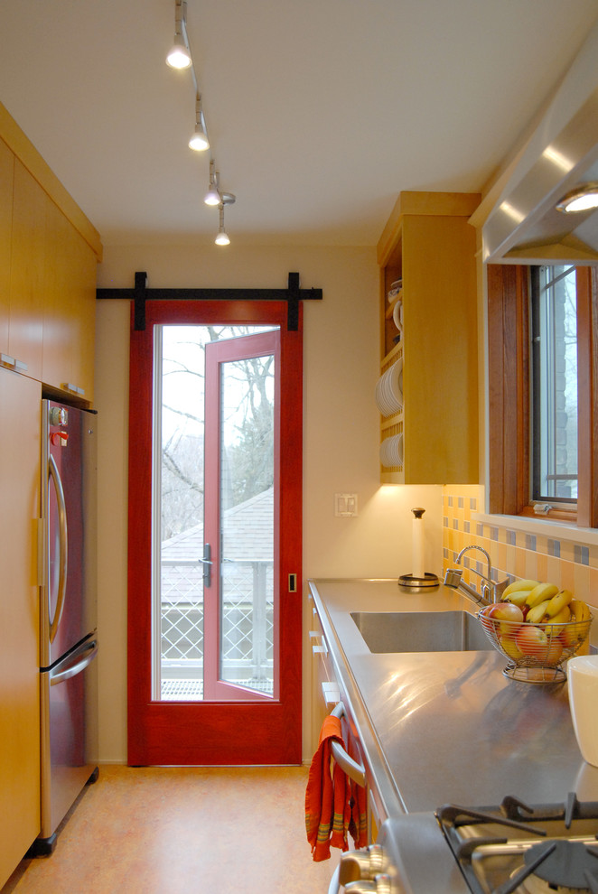 Zweizeilige, Geschlossene Moderne Küche mit Küchengeräten aus Edelstahl, integriertem Waschbecken, gelben Schränken, Edelstahl-Arbeitsplatte, Küchenrückwand in Gelb und flächenbündigen Schrankfronten in Sonstige