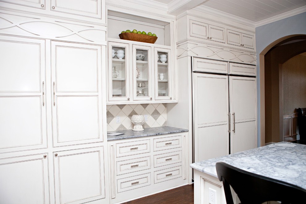 Idéer för ett stort klassiskt grå kök, med en undermonterad diskho, luckor med infälld panel, vita skåp, marmorbänkskiva, vitt stänkskydd, stänkskydd i tunnelbanekakel, integrerade vitvaror, mörkt trägolv, en köksö och brunt golv