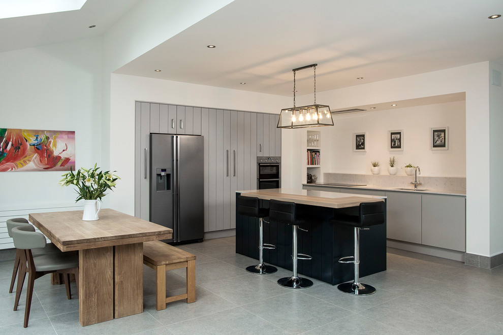 Große Moderne Wohnküche in L-Form mit Unterbauwaschbecken, flächenbündigen Schrankfronten, grauen Schränken, Küchengeräten aus Edelstahl und Halbinsel in Dublin