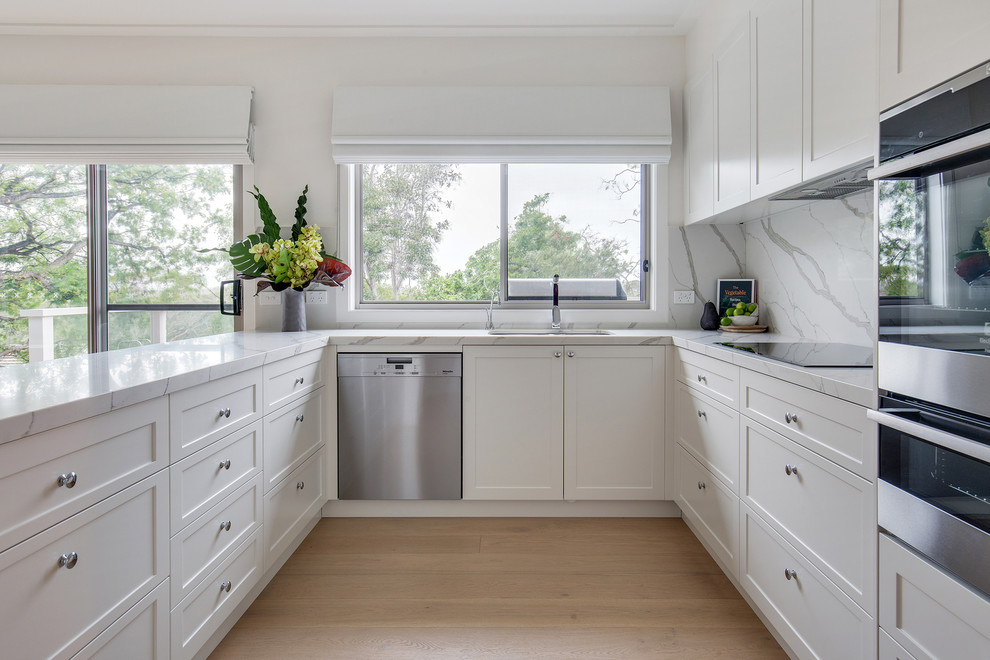 Exempel på ett stort modernt flerfärgad flerfärgat kök, med en nedsänkt diskho, skåp i shakerstil, vita skåp, bänkskiva i kvarts, vitt stänkskydd, stänkskydd i sten, vita vitvaror, mellanmörkt trägolv och beiget golv