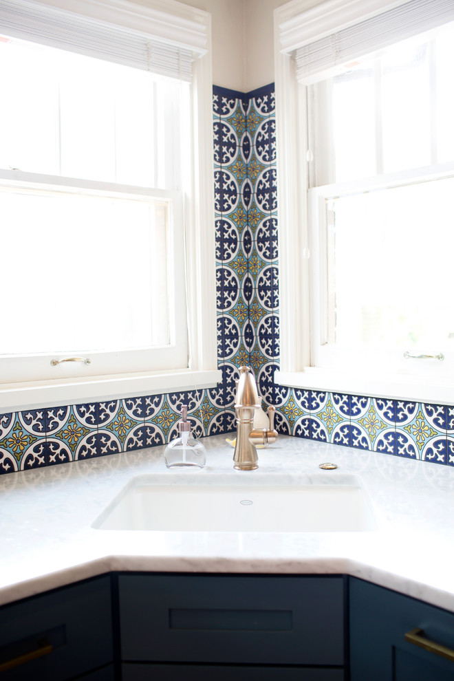 Diseño de cocina mediterránea con salpicadero azul y salpicadero de azulejos de cerámica