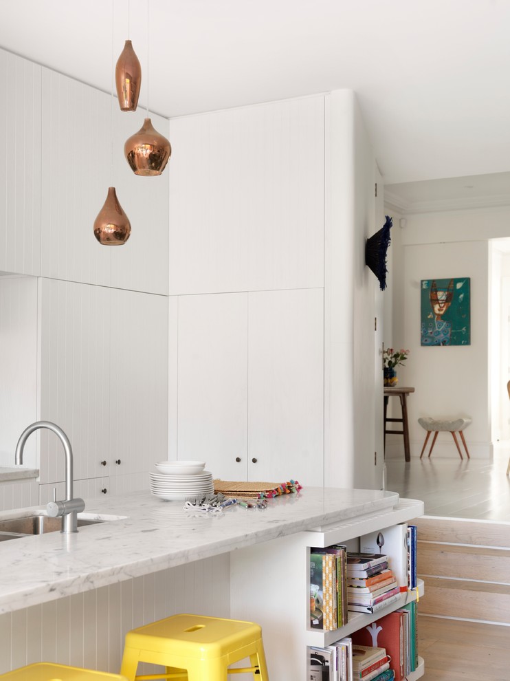 Mittelgroße, Zweizeilige Moderne Küche mit weißen Schränken, Marmor-Arbeitsplatte, Küchengeräten aus Edelstahl, hellem Holzboden und Kücheninsel in Sydney