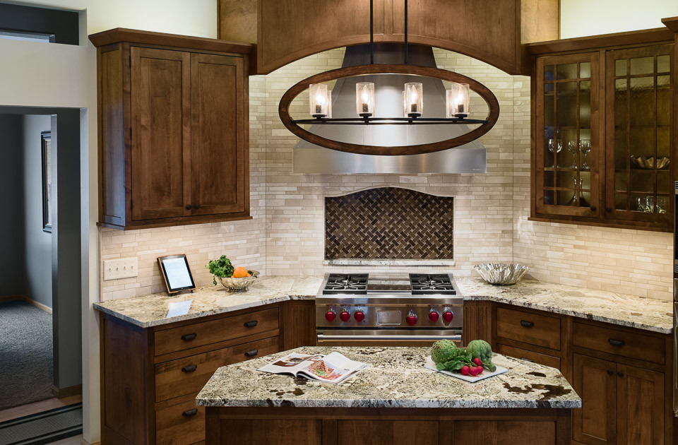 Eat-in kitchen - large rustic light wood floor eat-in kitchen idea in Minneapolis with an undermount sink, shaker cabinets, medium tone wood cabinets, granite countertops, beige backsplash, stone tile backsplash, stainless steel appliances and an island
