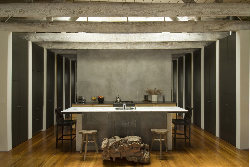 Urban galley kitchen photo in San Francisco with flat-panel cabinets, black cabinets, gray backsplash and marble countertops