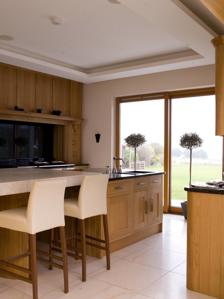 Ejemplo de cocina contemporánea con armarios estilo shaker, puertas de armario de madera oscura y una isla