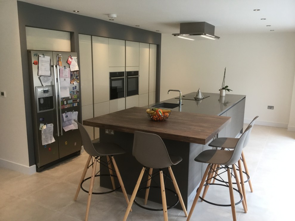 Modern single-wall open plan kitchen in Cardiff with flat-panel cabinets, grey cabinets, quartz worktops and an island.