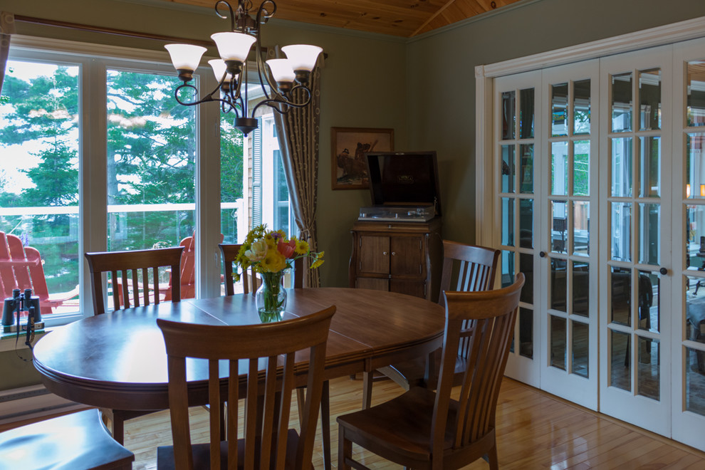 Foto di una sala da pranzo aperta verso la cucina stile shabby di medie dimensioni con pareti verdi e parquet chiaro