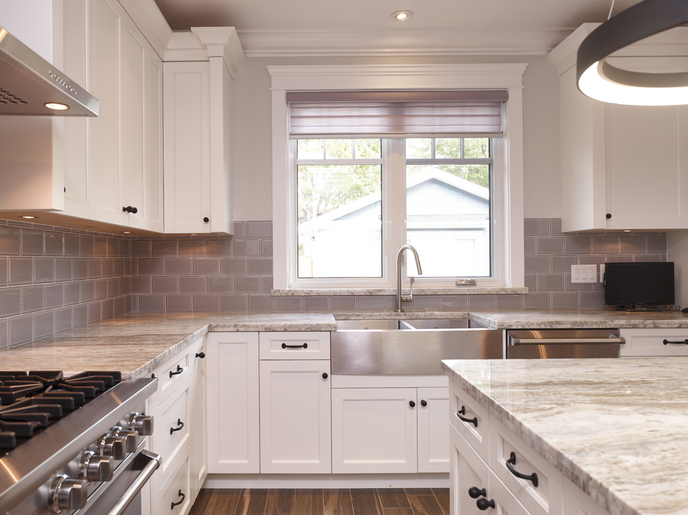 Kitchen - transitional u-shaped ceramic tile kitchen idea in Vancouver with an undermount sink, shaker cabinets, white cabinets, granite countertops, gray backsplash, subway tile backsplash, stainless steel appliances and an island