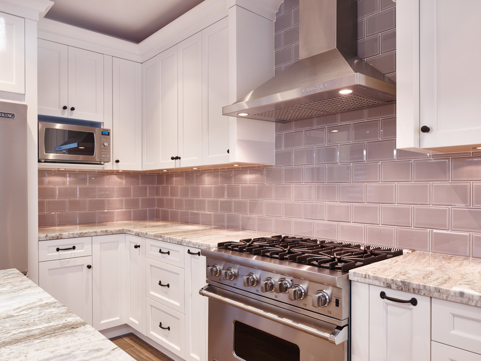 Example of a transitional u-shaped ceramic tile kitchen design in Vancouver with an undermount sink, shaker cabinets, white cabinets, granite countertops, gray backsplash, subway tile backsplash, stainless steel appliances and an island
