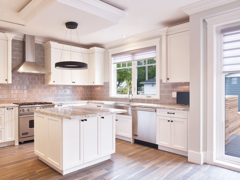 Transitional u-shaped ceramic tile kitchen photo in Vancouver with an undermount sink, shaker cabinets, white cabinets, granite countertops, gray backsplash, subway tile backsplash, stainless steel appliances and an island