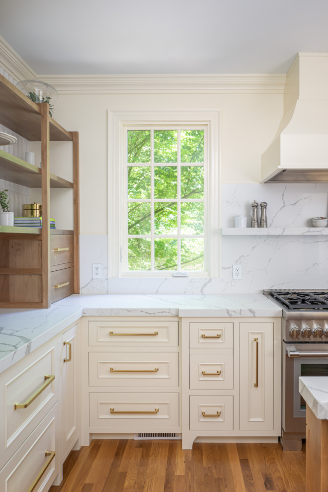 Idéer för ett avskilt, stort klassiskt vit u-kök, med en undermonterad diskho, luckor med upphöjd panel, vita skåp, bänkskiva i kvartsit, vitt stänkskydd, integrerade vitvaror, mellanmörkt trägolv, en köksö och brunt golv
