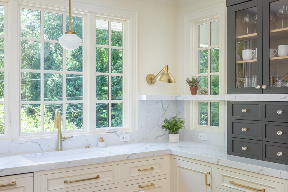 Exempel på ett avskilt, stort klassiskt vit vitt u-kök, med en undermonterad diskho, luckor med upphöjd panel, vita skåp, bänkskiva i kvartsit, vitt stänkskydd, integrerade vitvaror, mellanmörkt trägolv, en köksö och brunt golv