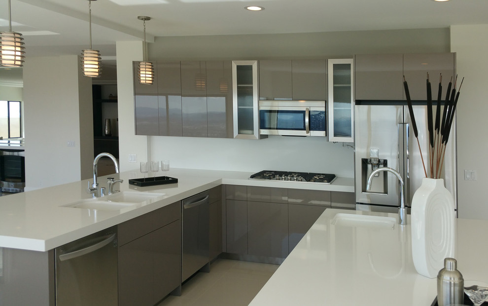 Example of a large minimalist linoleum floor eat-in kitchen design in Los Angeles with an undermount sink, flat-panel cabinets, dark wood cabinets, solid surface countertops, stainless steel appliances and two islands
