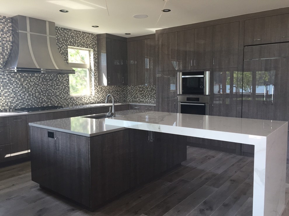 Inspiration for a large contemporary u-shaped porcelain tile open concept kitchen remodel in Seattle with an undermount sink, flat-panel cabinets, gray cabinets, quartz countertops, blue backsplash, mosaic tile backsplash, stainless steel appliances and an island