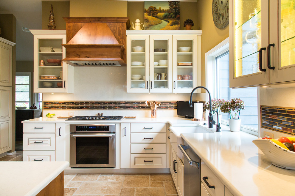 Inredning av ett klassiskt stort kök, med travertin golv, en rustik diskho, luckor med upphöjd panel, vita skåp, bänkskiva i kvarts, flerfärgad stänkskydd, en köksö, stänkskydd i glaskakel och rostfria vitvaror