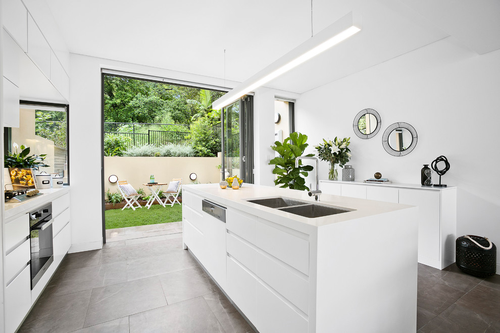 Offene, Zweizeilige, Mittelgroße Moderne Küche mit Doppelwaschbecken, weißen Schränken, Quarzwerkstein-Arbeitsplatte, Küchengeräten aus Edelstahl und Keramikboden in Sydney
