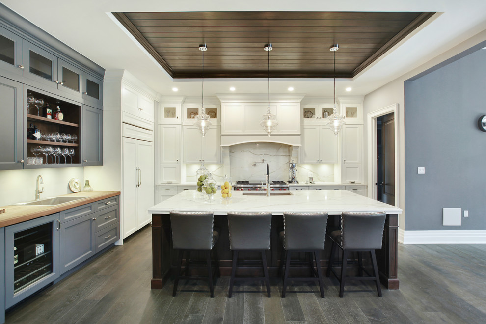 Eat-in kitchen - large transitional l-shaped eat-in kitchen idea in Toronto with an undermount sink, shaker cabinets, white backsplash, porcelain backsplash, stainless steel appliances and an island
