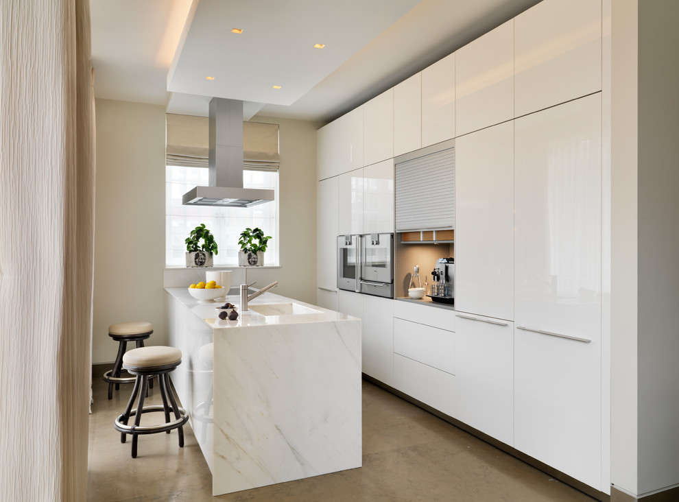 Foto di una cucina minimal chiusa e di medie dimensioni con lavello integrato, ante lisce, ante bianche, top in marmo, elettrodomestici da incasso, pavimento beige e top bianco