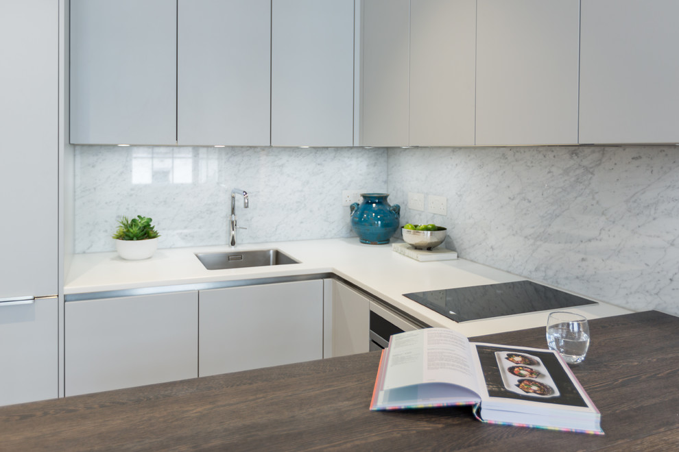 Idéer för ett mellanstort modernt vit kök, med en undermonterad diskho, släta luckor, grå skåp, bänkskiva i koppar, grått stänkskydd, stänkskydd i marmor, integrerade vitvaror, ljust trägolv och brunt golv