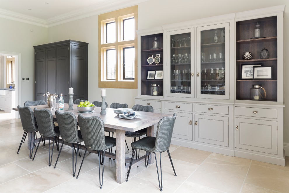 エセックスにあるラグジュアリーな広いトランジショナルスタイルのおしゃれなキッチン (グレーのキャビネット、ダブルシンク、ミラータイルのキッチンパネル、シルバーの調理設備、ライムストーンの床) の写真