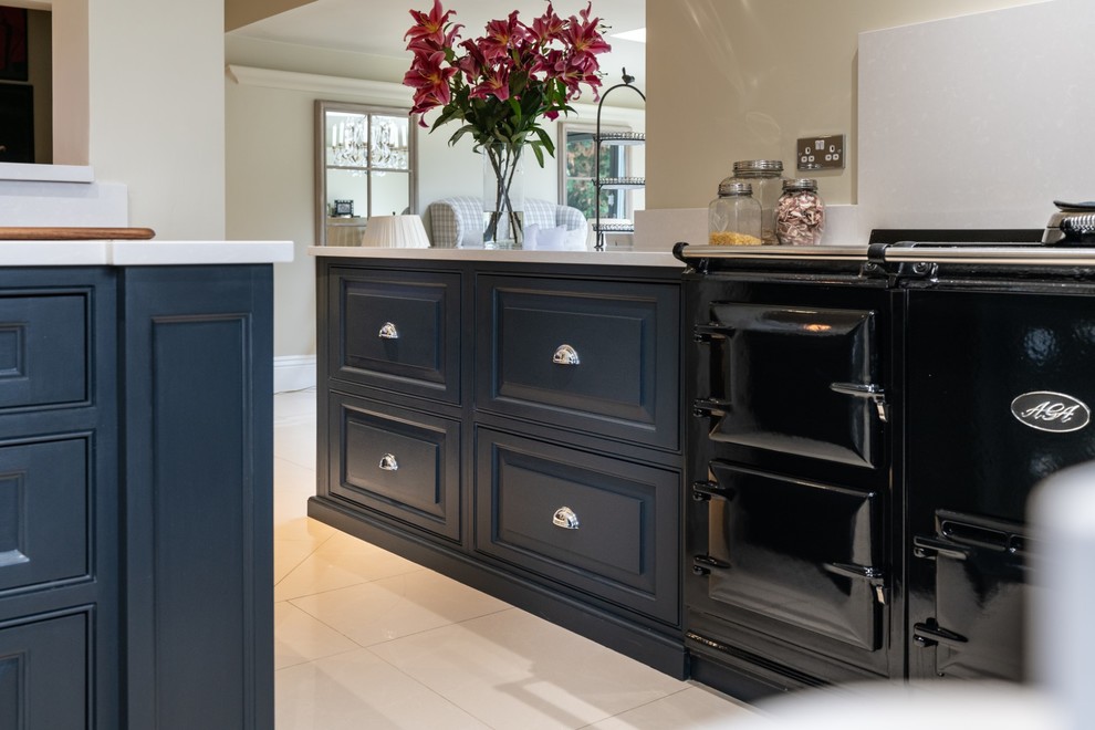 Inspiration for a large victorian l-shaped open plan kitchen in Essex with a double-bowl sink, raised-panel cabinets, blue cabinets, quartz worktops, ceramic flooring, an island, beige floors and white worktops.