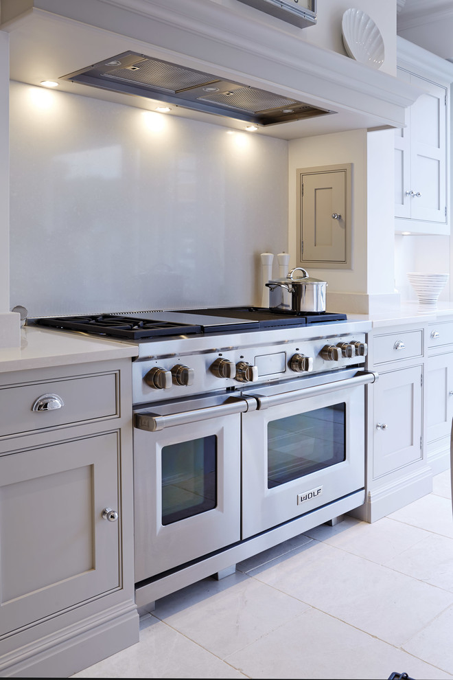 Inredning av ett kök, med skåp i shakerstil, grå skåp, rostfria vitvaror och marmorgolv