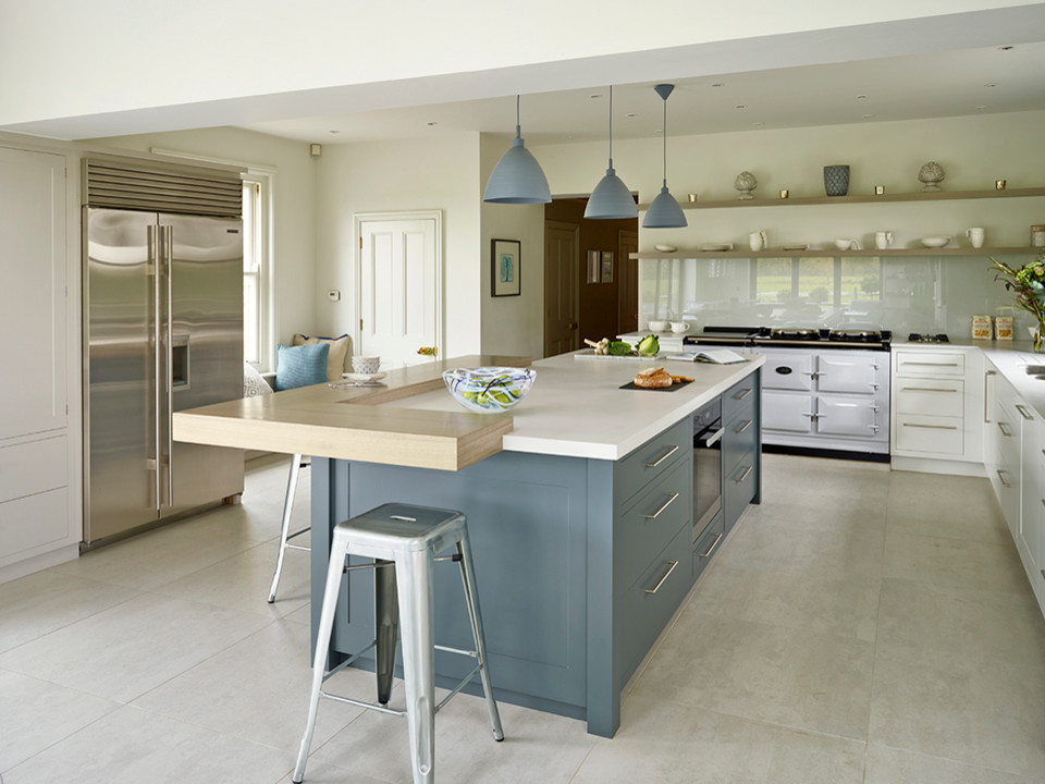 Inspiration for a large contemporary l-shaped kitchen/diner in Kent with a double-bowl sink, flat-panel cabinets, white cabinets, composite countertops, glass tiled splashback, stainless steel appliances, ceramic flooring and an island.