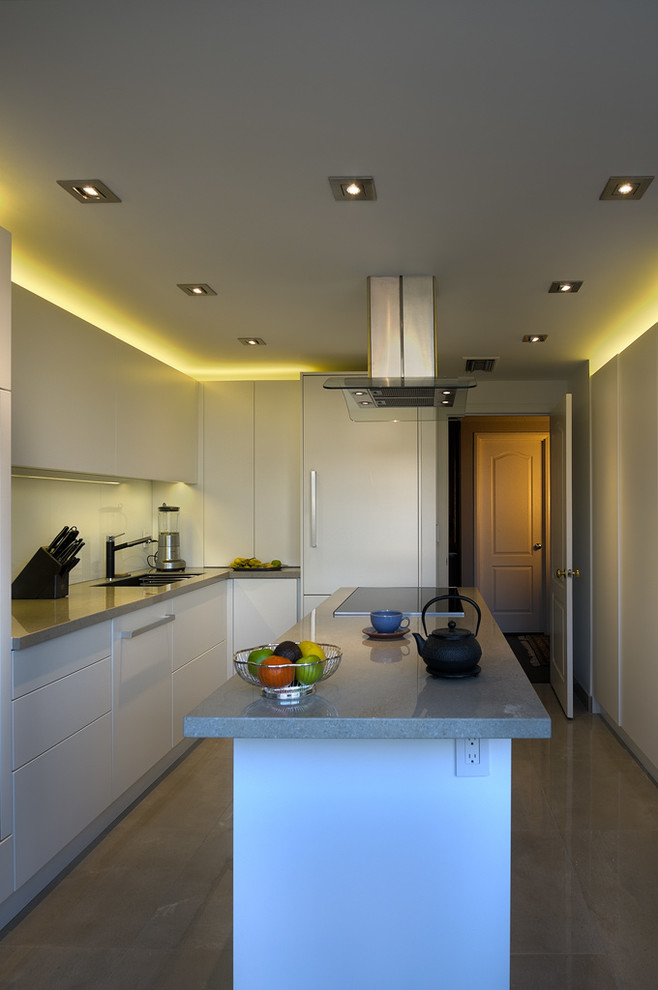 Immagine di una cucina minimalista chiusa con lavello sottopiano, ante lisce, ante bianche, top in superficie solida, paraspruzzi bianco, elettrodomestici in acciaio inossidabile e pavimento in gres porcellanato