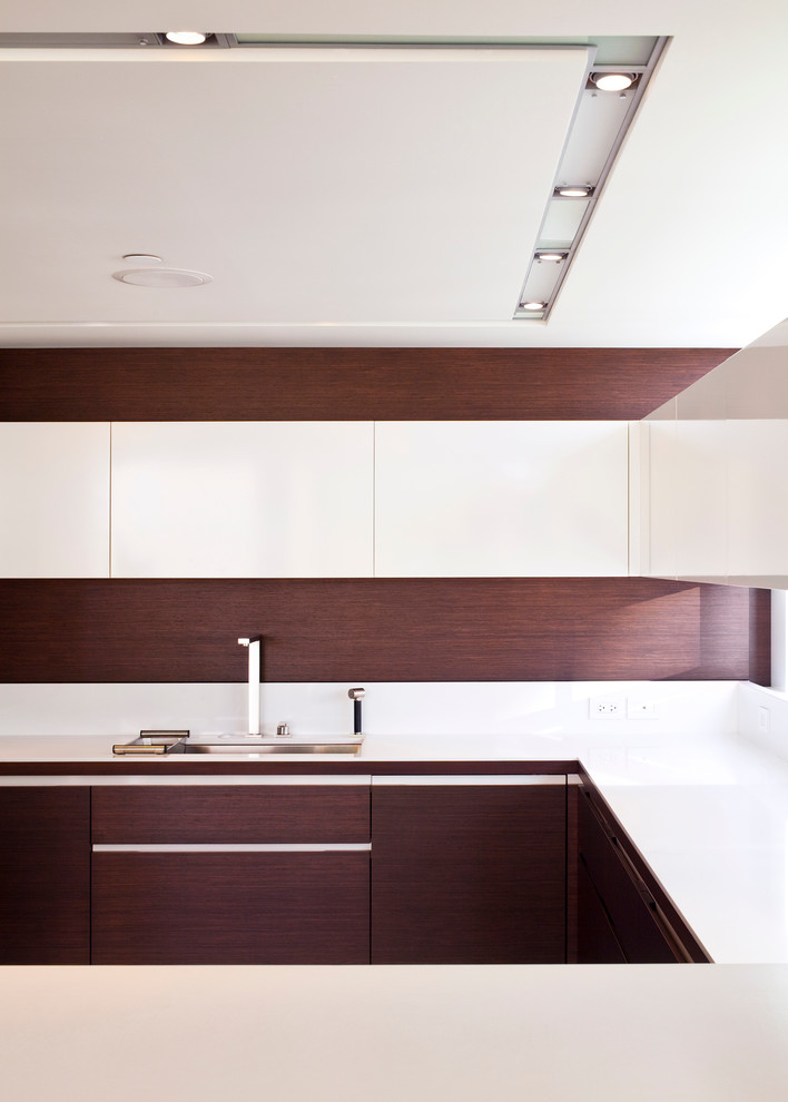 Moderne Wohnküche in U-Form mit flächenbündigen Schrankfronten, weißen Schränken, Küchenrückwand in Braun, Unterbauwaschbecken und Elektrogeräten mit Frontblende in Vancouver