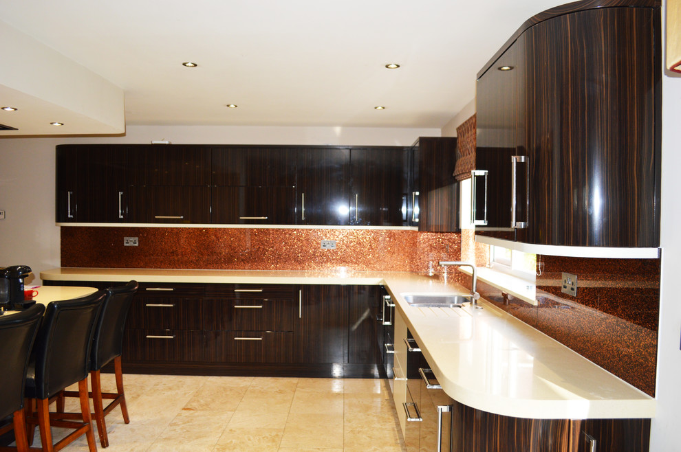 Große Moderne Wohnküche mit flächenbündigen Schrankfronten, hellbraunen Holzschränken, Marmor-Arbeitsplatte, Küchenrückwand in Orange, Glasrückwand und Kücheninsel in Hertfordshire