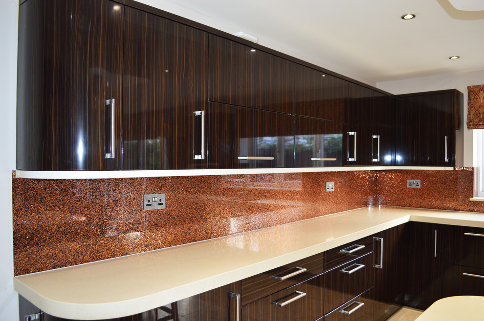 Ispirazione per una grande cucina minimalista con ante lisce, ante in legno scuro, top in marmo, paraspruzzi arancione e paraspruzzi con lastra di vetro