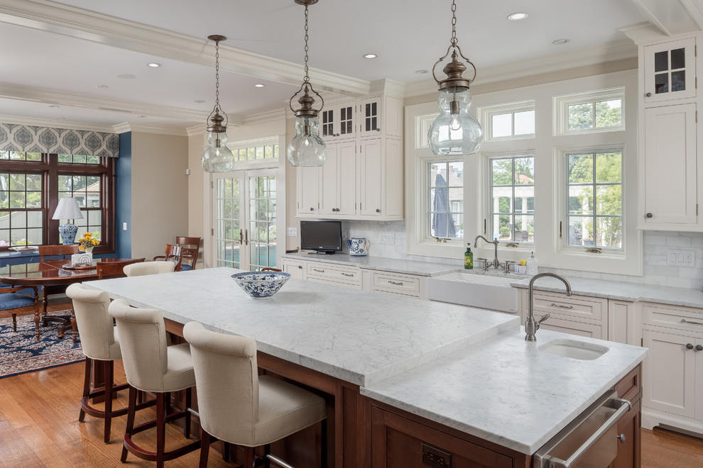 Large beach style medium tone wood floor eat-in kitchen photo in Bridgeport with a farmhouse sink, marble countertops, an island, white countertops, shaker cabinets, white cabinets, white backsplash and marble backsplash
