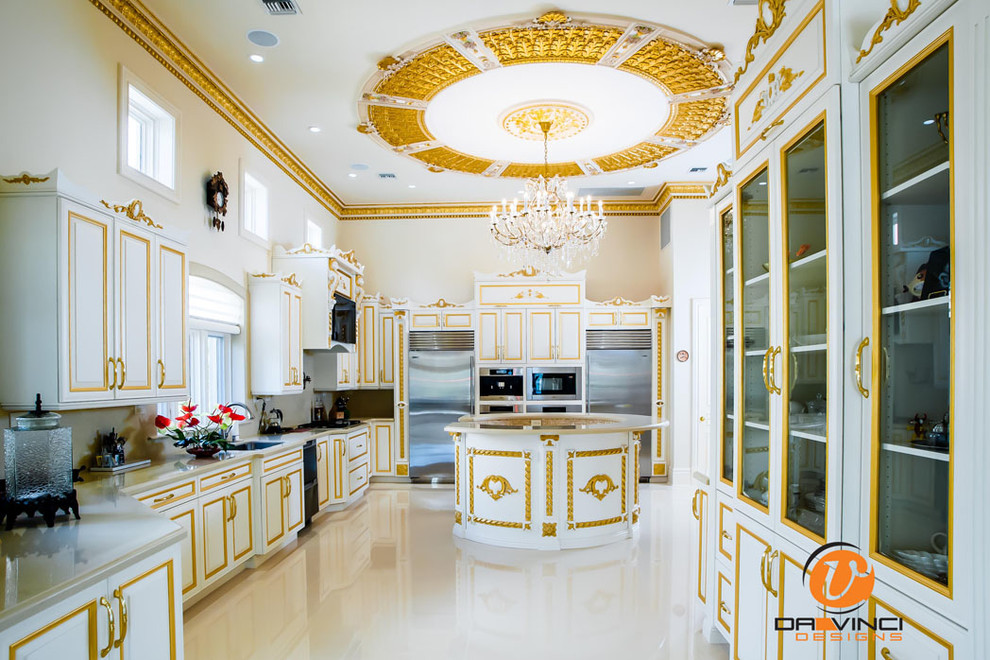 Inredning av ett klassiskt stort kök, med vita skåp, luckor med infälld panel, granitbänkskiva, beige stänkskydd, rostfria vitvaror och en köksö