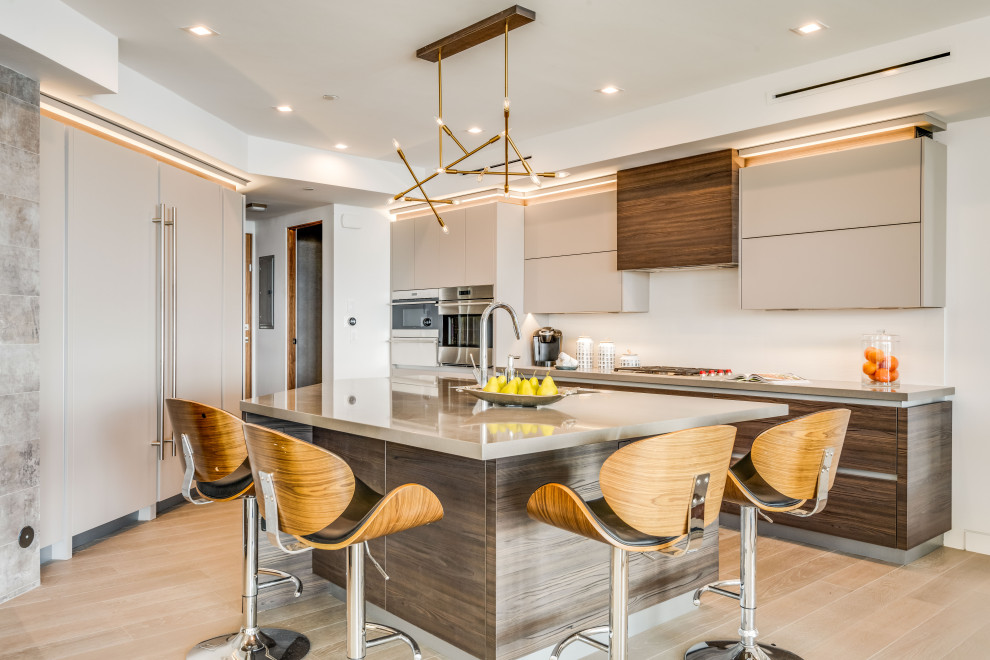 This is an example of a large contemporary open plan kitchen in Los Angeles with a submerged sink, flat-panel cabinets, brown cabinets, engineered stone countertops, white splashback, stone slab splashback, integrated appliances, porcelain flooring, an island and grey worktops.